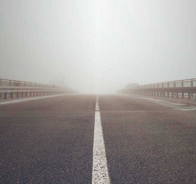 Autobahn mit Schutzstreifen läuft bis zum Horizont ins Licht